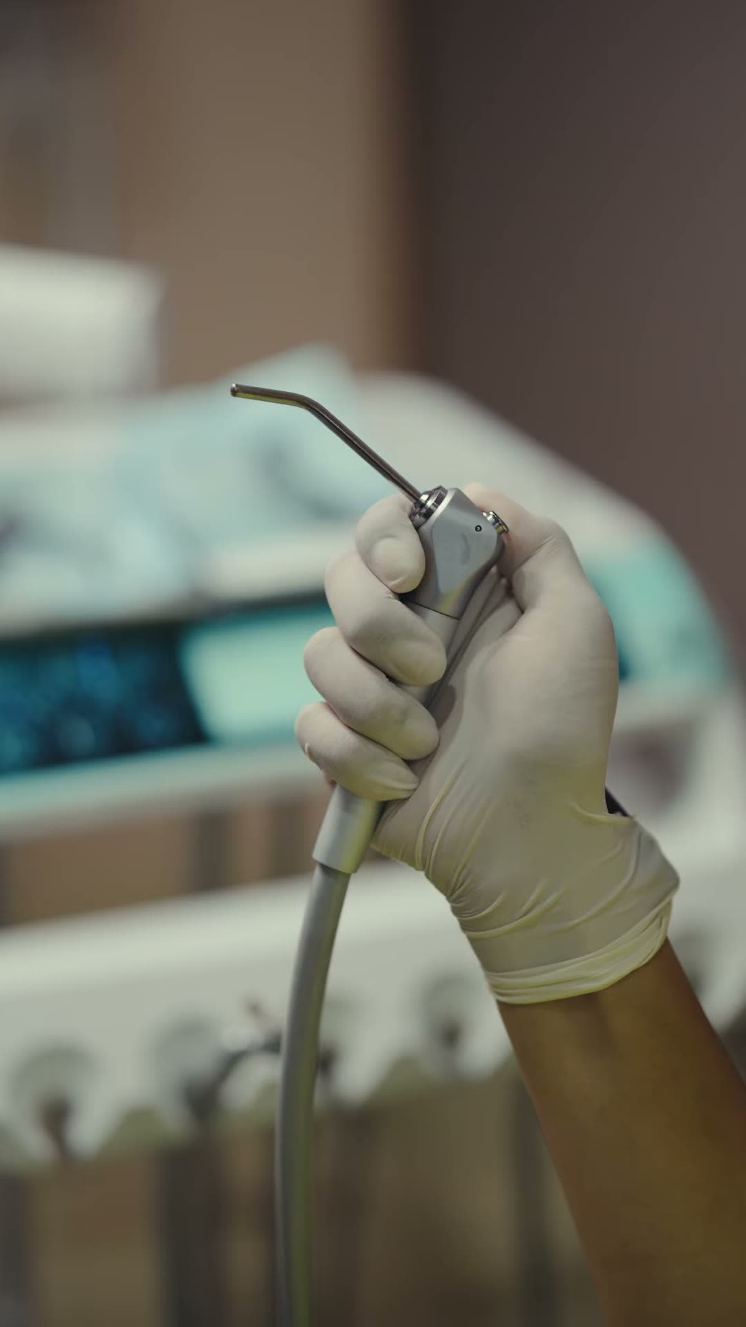 Precision dental handpiece in a gloved hand